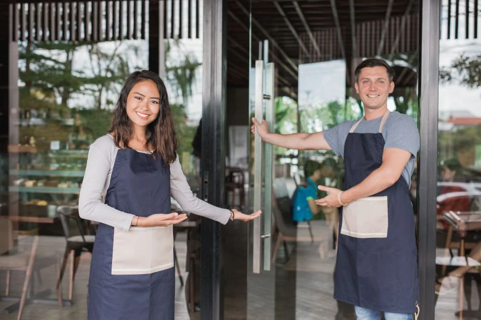 two servers welcoming people into a restaurant