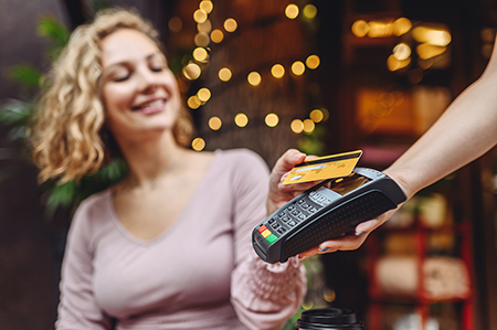 woman paying at a cafe with her credit card